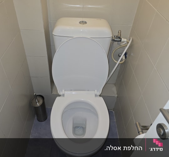 אסלה עם מברשת ניקוי בחדר שירותים קטן